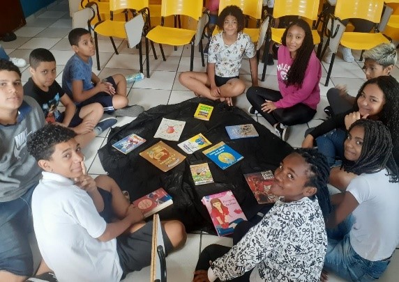 Diverse group of students around a table creating a theatrical play