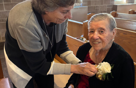 Sister Karen Kane helps Sister Mary Ann Bazata with her corsage 